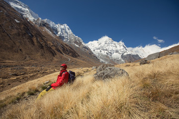 Obraz premium Tourist man sitting and relax on Annapurna background. Mountain travel landscape in Nepal