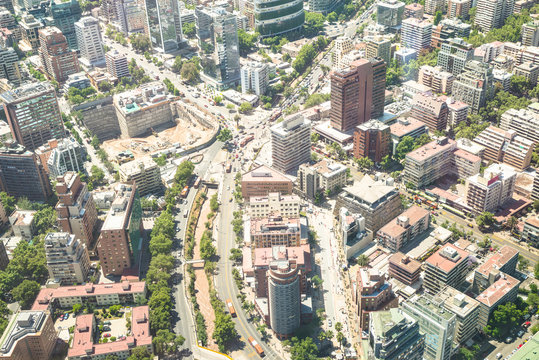Detail of skyscrapers in downtown district of Santiago de Chile - Aerial view of modern buildings and skyline in chilean biggest city with green areas and streets intersection - Bright desat filter