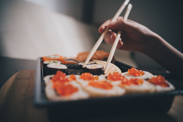 Set sushi set. Hand with chopsticks for sushi.
