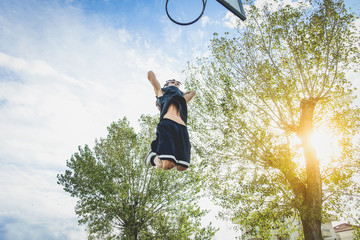 Basketball athlete doing huge slam dunk on the court i