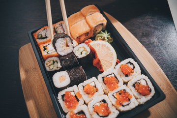 Set sushi set. Hand with chopsticks for sushi.

