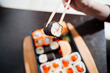 Set sushi set. Hand with chopsticks for sushi.
