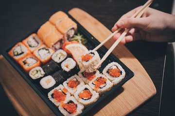 Set sushi set. Hand with chopsticks for sushi.
