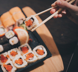 Set sushi set. Hand with chopsticks for sushi.
