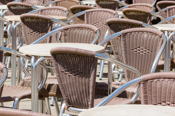 Close up from many moder brown metal chairs and tables outdoor in restaurant in venedig
