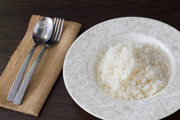 White Rice in the dish on dark brown wooden plate
