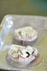 Raw fish colin with cheese Roquefort in a refractory dish for baking
