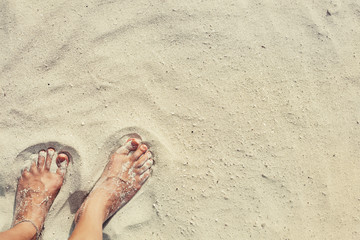 Female feet in white beach sand