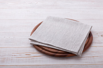 Pizza board with napkin on wooden table. Top view mockup