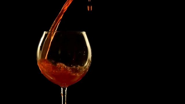 Red wine poured into glass black background