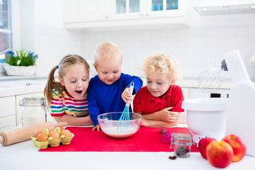 Kids baking a pie in white kitchen