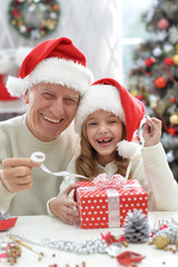 Fototapeta na wymiar Grandfather and child in Santa hats