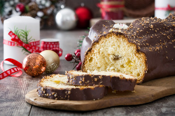 Fototapeta na wymiar Chocolate yule log christmas cake and christmas ornament on wooden background 