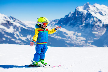 Fototapeta na wymiar Ski and snow fun for child in winter mountains