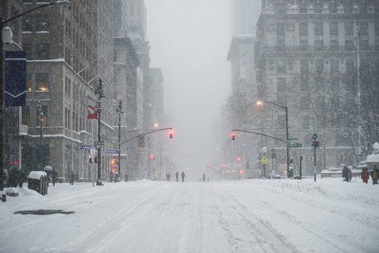 New York City Manhattan Midtown street under the snow during snow blizzard in winter. Empty 5th avenue with no traffic.