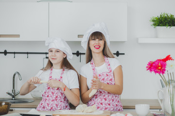 Mother with her daughter are preparing the buns