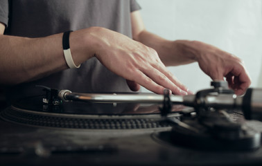 Music background.  DJ plays vinyl records. DJ's hands and turntable close up