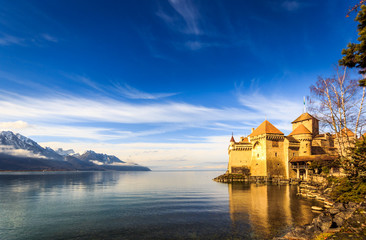 Castle on a lake front with blue sky and mountains