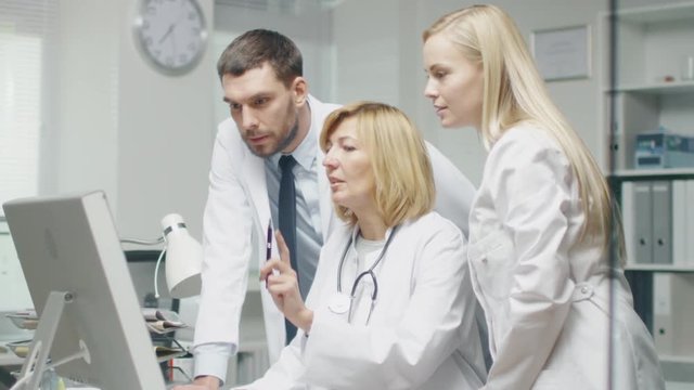Medical Personnel Discuss Work Related Issues while Using Personal Computer. They Point at the Screen and Talk. Shot on RED Cinema Camera in 4K (UHD).