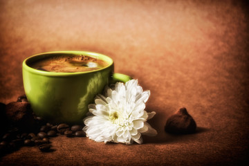 still life. warm cup of coffee on brown background. Dramatic interpretation. Low key, dark background, spot lighting, and rich Old Masters colors.