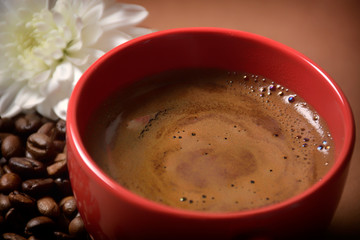 still life. warm cup of coffee on brown background. Dramatic interpretation. Low key, dark background, spot lighting, and rich Old Masters colors.
