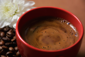 still life. warm cup of coffee on brown background. Dramatic interpretation. Low key, dark background, spot lighting, and rich Old Masters colors.