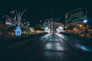 Fototapeta na wymiar Tram tracks and buildings at night, in downtown Norfolk, Virgini