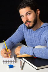 Male college student with books and notepad.