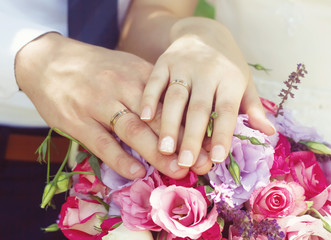 Obraz na płótnie Canvas Hands of groom and bride on a wedding bouquet.