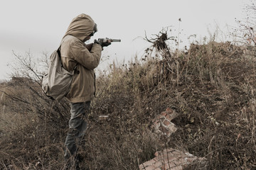 wandering boy. young boy aiming a gun. boy shoots. Post apocalypse. Boy traveling on foot in a post-apocalyptic world in search of food. post-apocalyptic world. boy with a gun