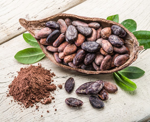 Cocoa powder and Cocoa beans on the wooden table.