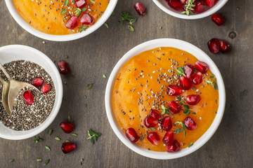 Detox and healthy breakfast smoothie of ripe juicy fruits  persimmon, pomegranate seeds, chia  with honey  thyme on a dark wooden background. Top view. The concept  organic food.