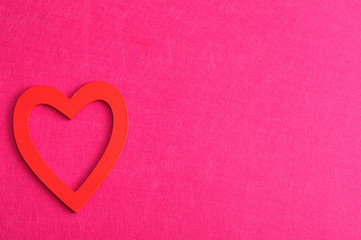 Valentine's Day. A red heart isolated against a pink background