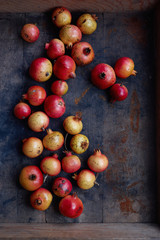 High angle view of ripe red organic pomegranates in crate