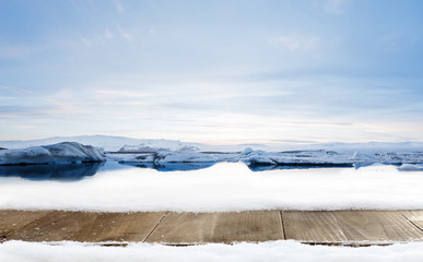 Wooden desk and winter decoration of snow with glacier landscape