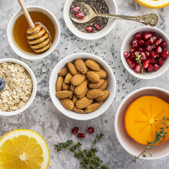 Ingredients for a healthy breakfast, nuts, oatmeal, honey, berries, fruits, blueberry, orange, pomegranate seeds, almonds, walnuts The concept of natural organic food in season Top