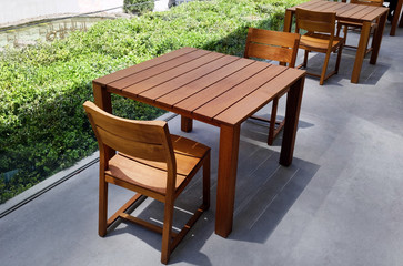 Outdoor restaurant wood tables and chairs. Nobody.