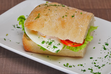 Ciabatta panini sandwich with chicken and tomato. Sandwich stuffed with sausage, egg and tomato.