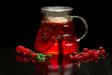 Berry tea with fresh currants, raspberries and strawberries. Teapot with fruits and berries.