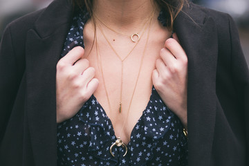 perfect fall outfit accessories. fashion blogger wearing a black elegant coat, a v-neck see through shirt and a beautiful and trendy golden chain necklace

 - obrazy, fototapety, plakaty