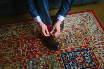 closeup of man's hands tying shoelace