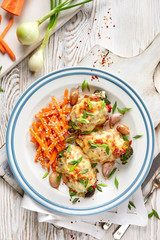 Roasted teriyaki chicken thighs  stuffed with vegetables, baked with mozzarella cheese on a white plate, top view