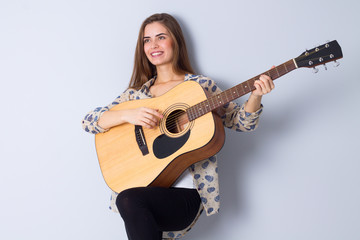 Fototapeta premium Young woman holding a guitar 