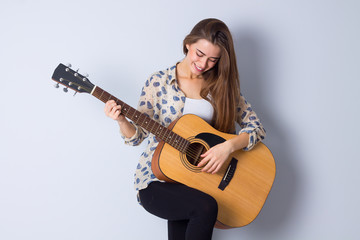 Fototapeta premium Young woman holding a guitar 