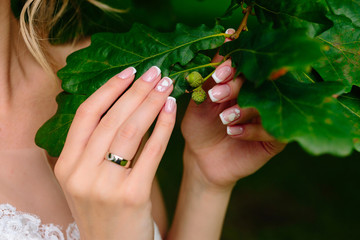 Fototapeta premium Wedding rings and beautiful manicure bride