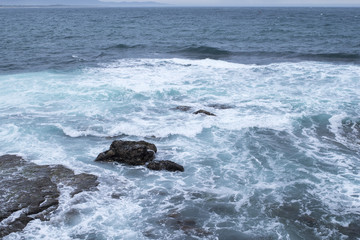 seascape, turquoise waters of the ocean beating on the coastal rocks