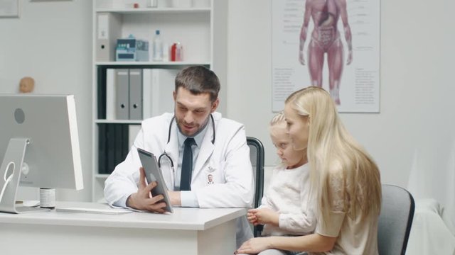 Male Doctor Consults Young Girl and Her Mother with a Help of a Tablet. They Smile Warmly.
 Shot on RED Cinema Camera in 4K (UHD).