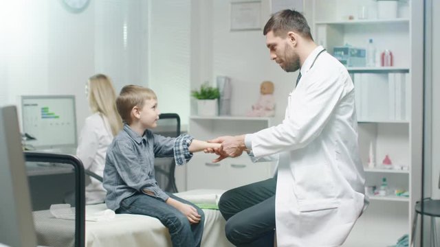 Doctor Cheks Young Boy's Hand For Signs of Injury. Shot on RED Cinema Camera in 4K (UHD).