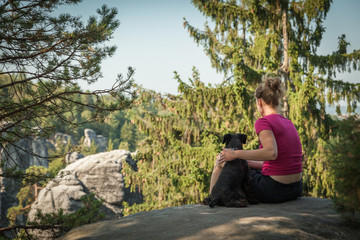 Fototapeta premium Young woman and her dog enjoy mountain hikes in summer