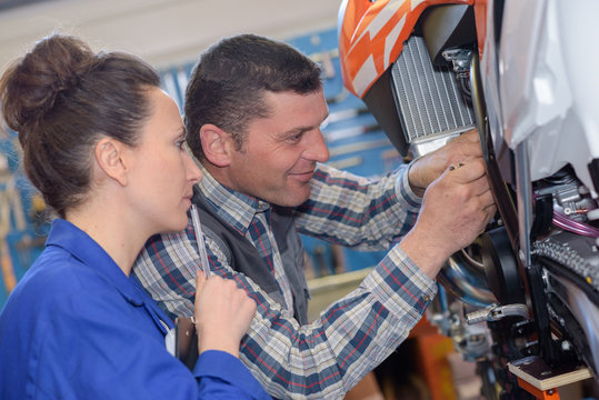 mechanic repairs the carburetor of his motorcycle